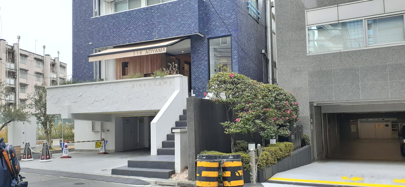青いタイルの建物。入口の上に316 AOYAMAの表示